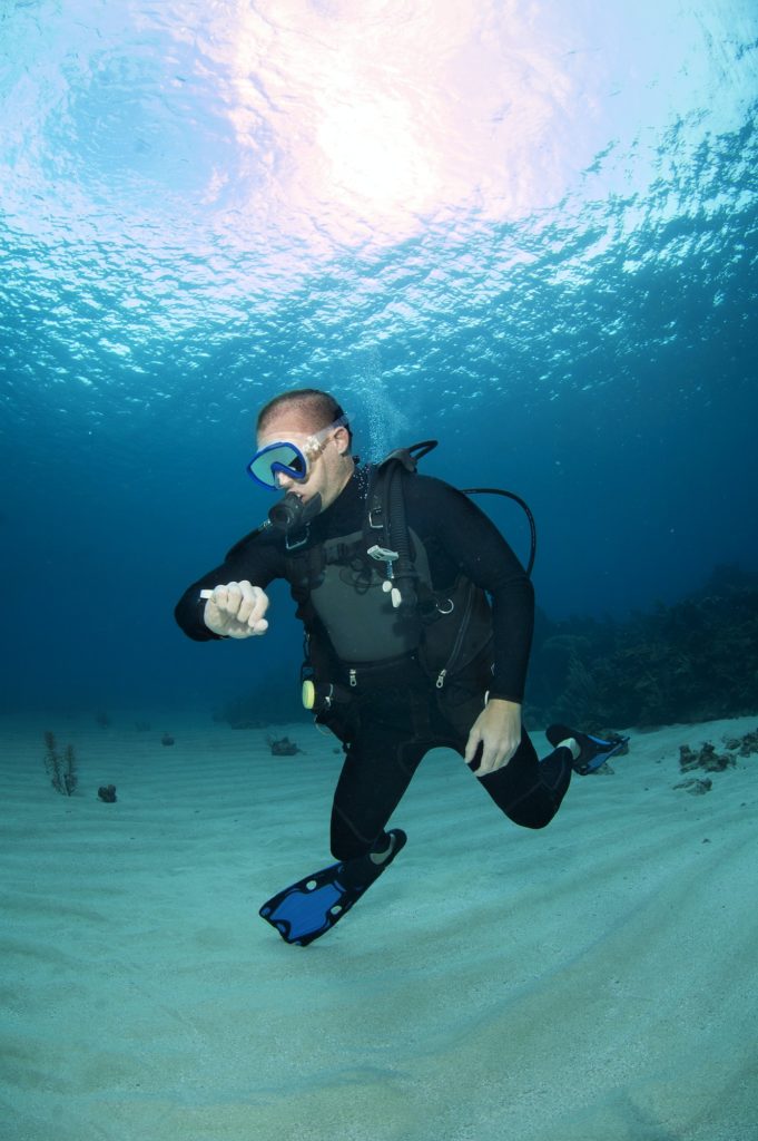 Scuba Diver Checking Oxygen Pressure In Sea